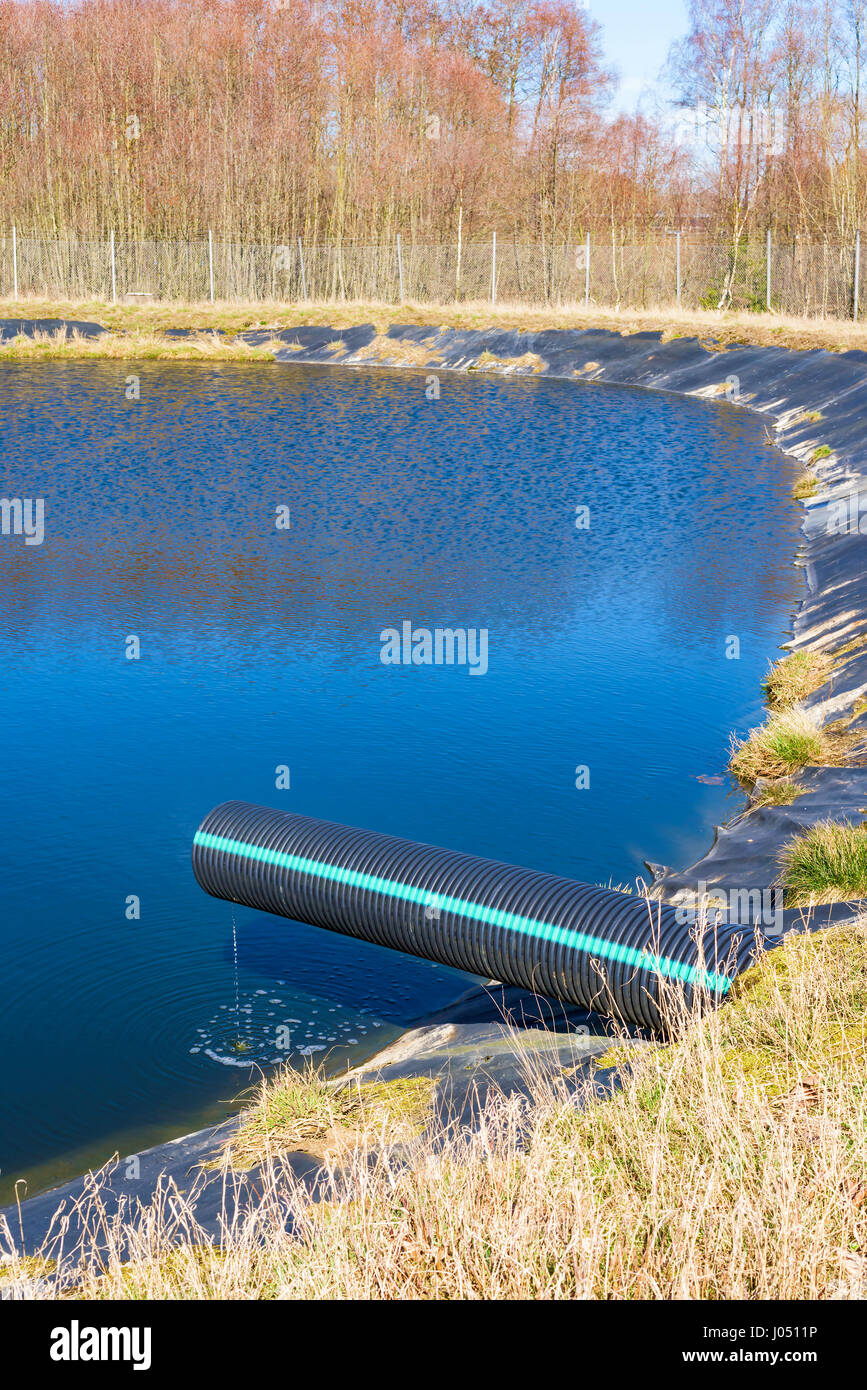 Le lixiviat de verser dans un étang de tuyau noir et bleu. Location Ronneby, Suède. Banque D'Images