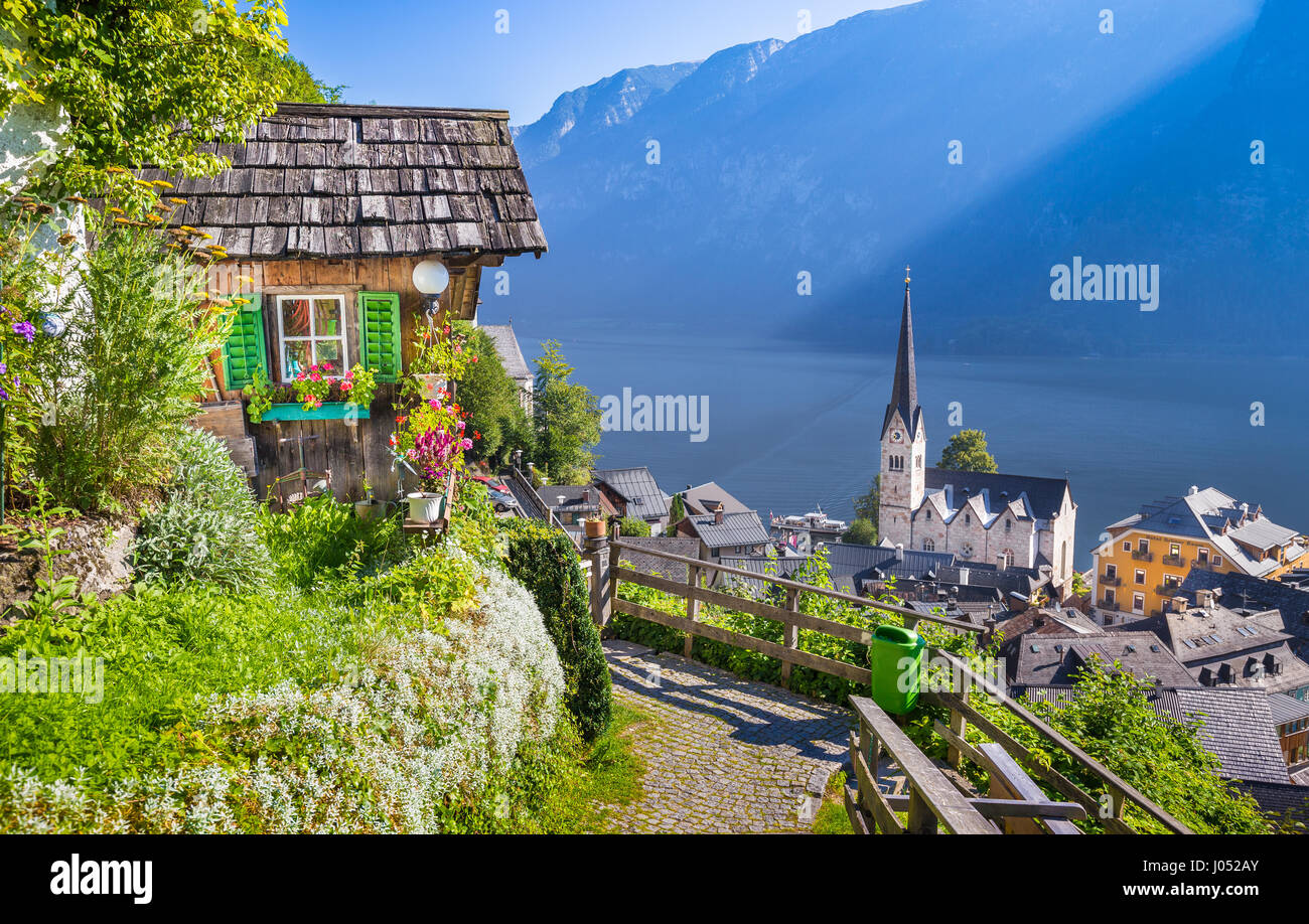 Vue de carte postale classique de la célèbre ville au bord du lac de Hallstatt dans les Alpes avec sentier idyllique menant jusqu'à une colline sur une belle journée ensoleillée avec ciel bleu Banque D'Images