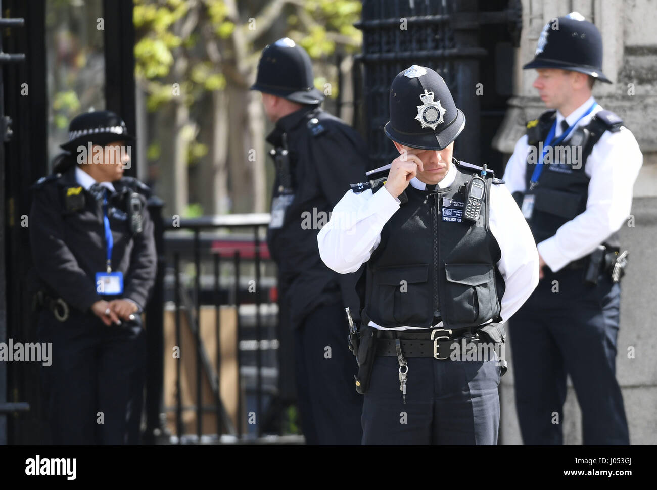 Un agent de police se frotte les yeux devant les Maisons du Parlement, Londres, dans la perspective de l'enterrement de Keith Palmer Pc. Banque D'Images