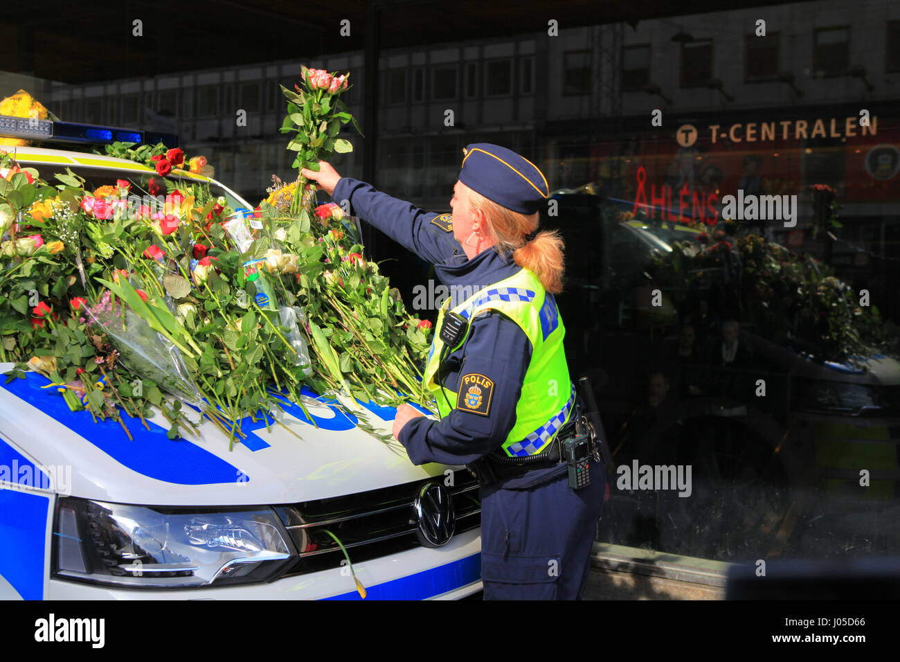 Scènes émotionnelle sur le site de l'attaque du chariot de Stockholm. Les gens sont venus déposer des fleurs sur une voiture de police le dimanche après l'attaque. Banque D'Images Scènes émotionnelle sur le site de l'attaque du chariot de Stockholm. Les gens sont venus déposer des fleurs sur une voiture de police le dimanche après l'attaque. Banque D'Images