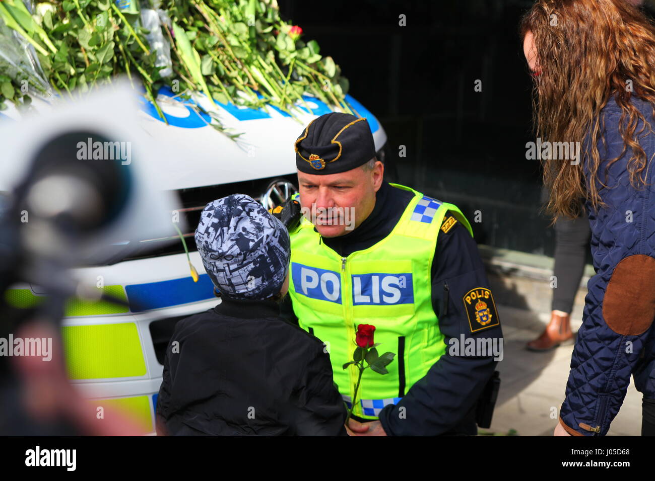 Scènes émotionnelle sur le site de l'attaque du chariot de Stockholm. Les gens sont venus déposer des fleurs sur une voiture de police le dimanche après l'attaque. Banque D'Images Scènes émotionnelle sur le site de l'attaque du chariot de Stockholm. Les gens sont venus déposer des fleurs sur une voiture de police le dimanche après l'attaque. Banque D'Images
