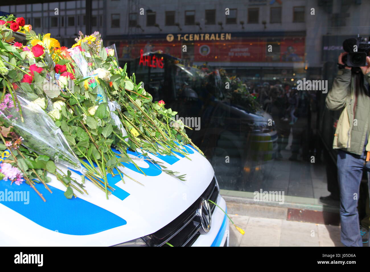 Scènes émotionnelle sur le site de l'attaque du chariot de Stockholm. Les gens sont venus déposer des fleurs sur une voiture de police le dimanche après l'attaque. Banque D'Images Scènes émotionnelle sur le site de l'attaque du chariot de Stockholm. Les gens sont venus déposer des fleurs sur une voiture de police le dimanche après l'attaque. Banque D'Images