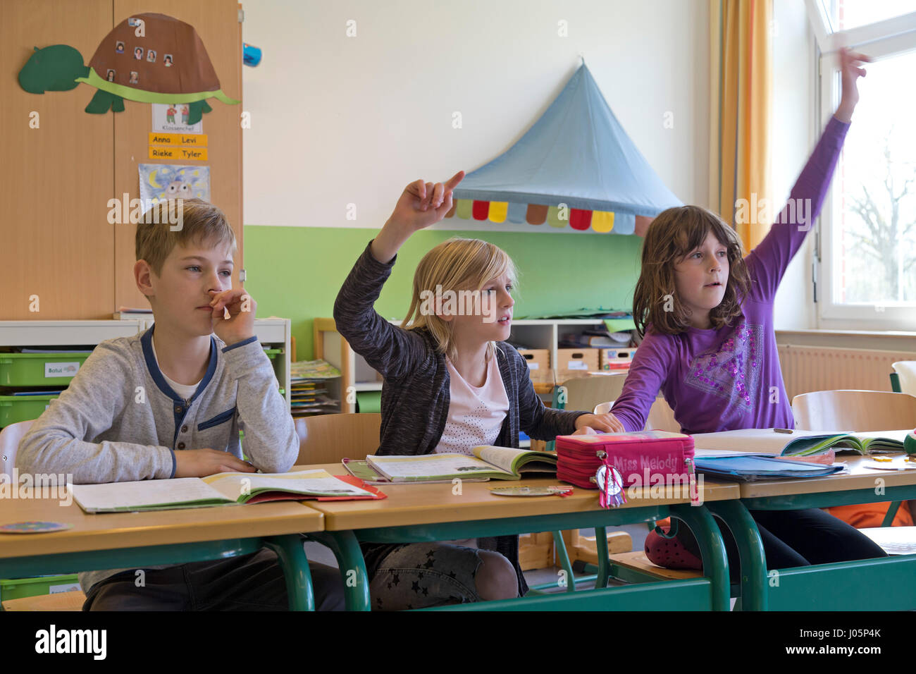 Les élèves d'école primaire en levant la main, Basse-Saxe, Allemagne Banque D'Images