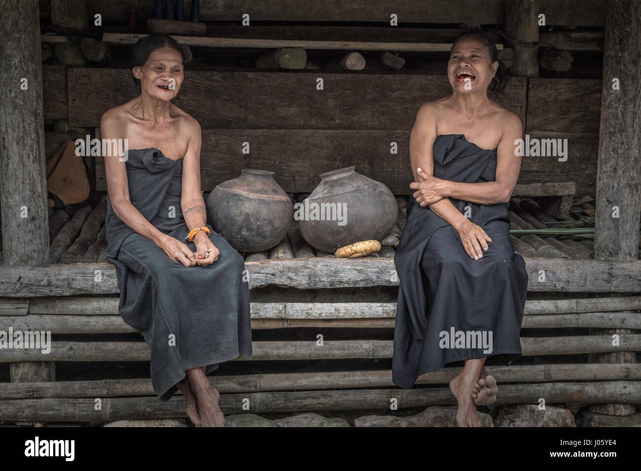 Deux femmes âgées de la tribu Loli se détendre devant leur maison Banque D'Images