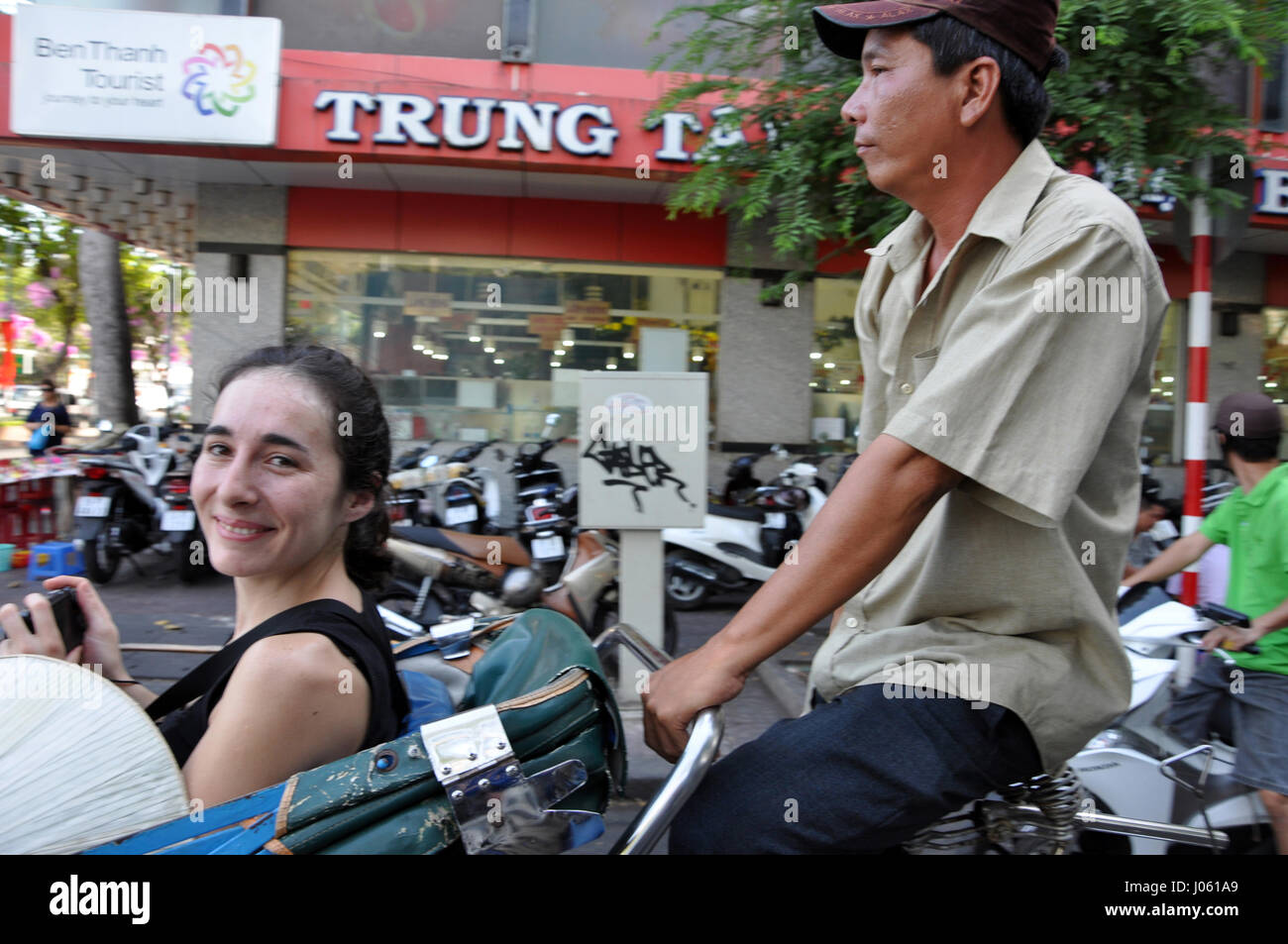 HO CHI MINH, VIETNAM - 15 février 2013 : une visite touristique avec un pousse-pousse Vietnamien classique, tuk tuk à Saigon Banque D'Images