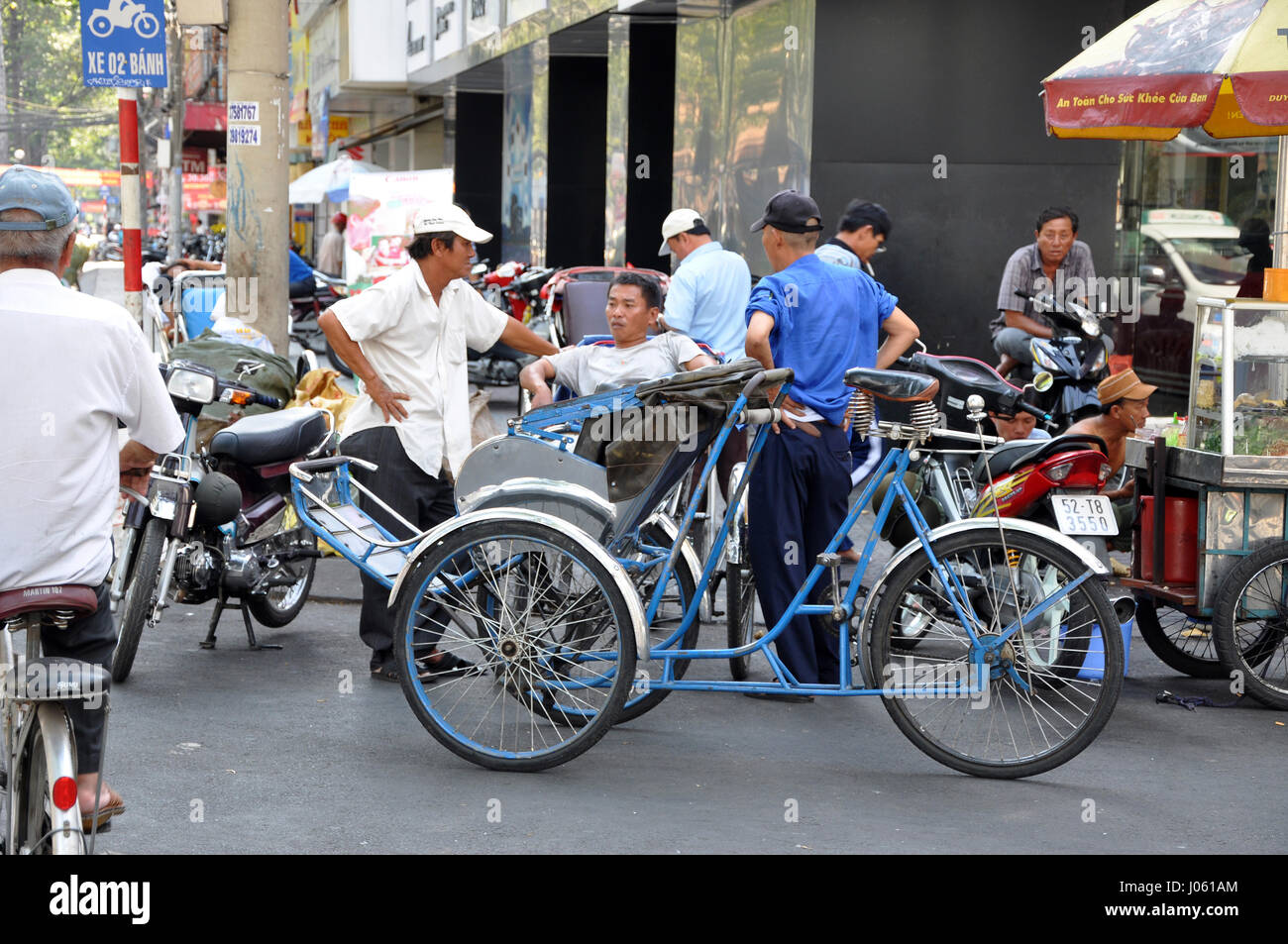 HO CHI MINH, VIETNAM - 15 février 2013 : une visite touristique avec un pousse-pousse Vietnamien classique, tuk tuk à Saigon Banque D'Images