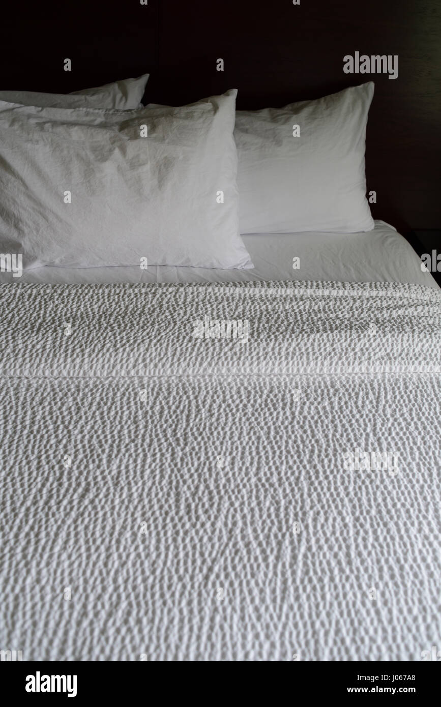 Des draps blancs sur un lit d'hôtel Banque D'Images