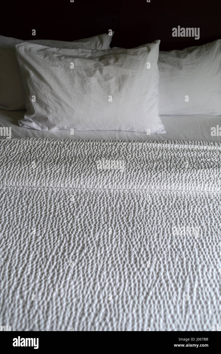 Des draps blancs sur un lit d'hôtel Banque D'Images