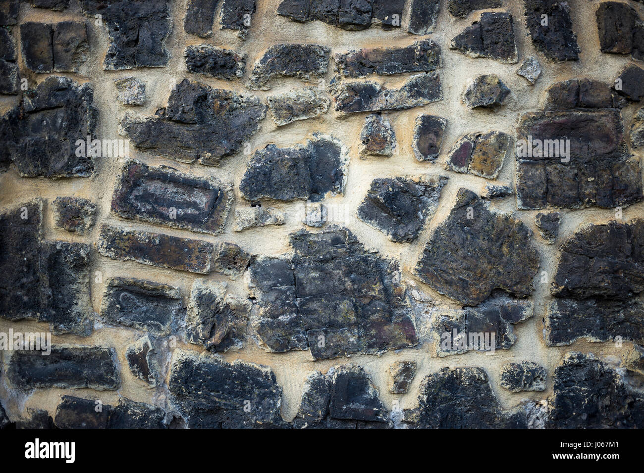 Motif décoratif de couleur gris fissuré inégale à la surface du mur en pierre avec du ciment Banque D'Images