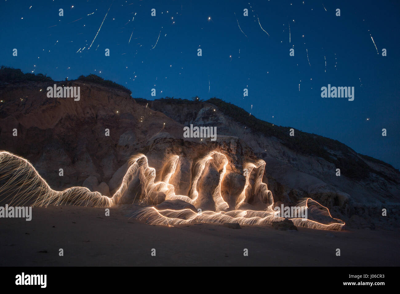 PLATEAU CENTRAL brésilien, BRÉSIL : feu d'artifice ont été utilisées pour créer des œuvres d'art uniques représentant la nature transitoire de la vie. La série nommée 'entités' montre orange-feu tourbillons et de veines superposées contre nature. Motifs de lumière peut être vu à la danse sur l'eau, de roches et de sable ainsi que de vieux arbres majestueux dans un affichage spectaculaire. Le photographe brésilien Vitor Schietti (30) a créé cette plage éclairante d'art, dans son pays d'origine en utilisant le Plateau Central brésilien comme sa toile de fond. Banque D'Images