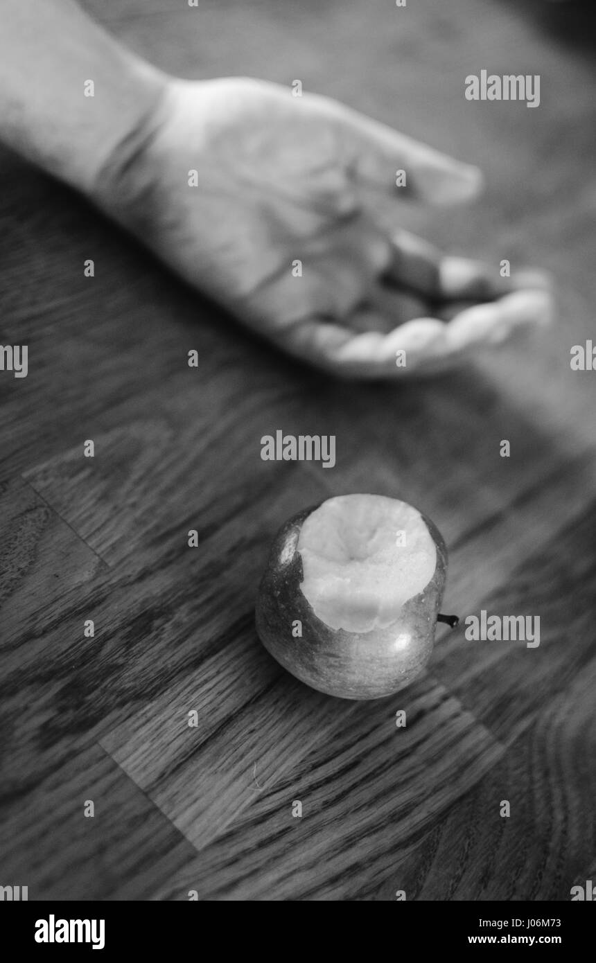 La main blanche neige étendue sur le sol après avoir mordu pomme empoisonnée Banque D'Images