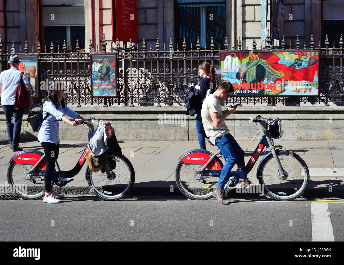 Un couple d'une ONM borris bikes s'arrêter au bord de la route pour vérifier les directions sur smartphone à Londres Banque D'Images