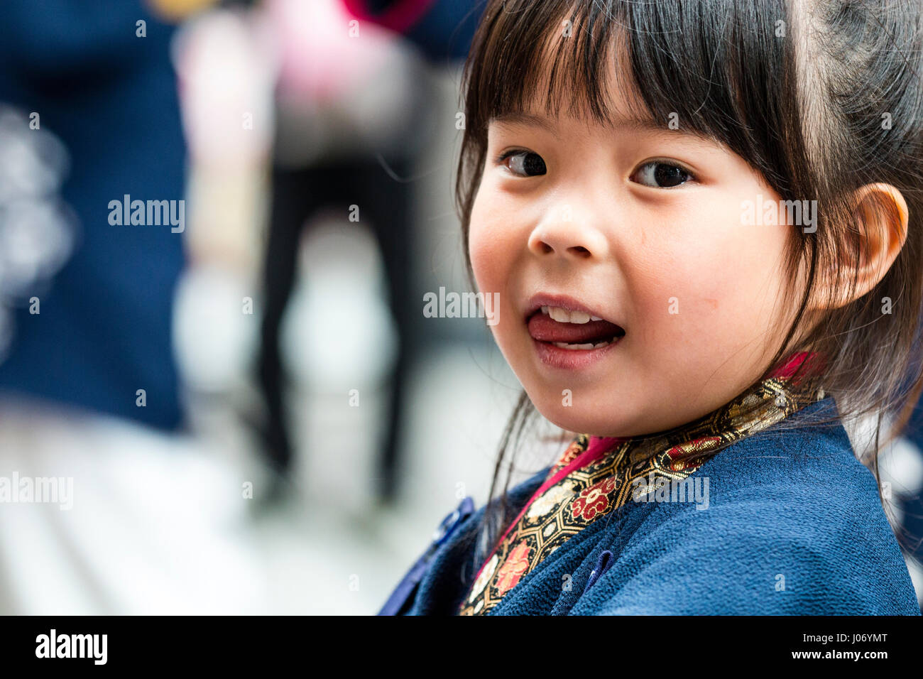 Festival Danse Yosakoi Hinokuni. L'enfant japonais, fille, 4-5 ans, la tête et l'épaule, le visage se tourna pour regarder viewer, le contact visuel, de la langue des coups. Banque D'Images