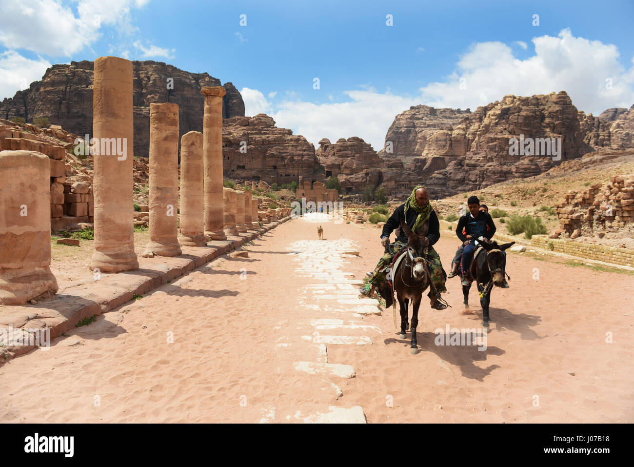 Ride hommes bédouins ânes thier par la rue Colonnade dans la ville antique de Petra. Banque D'Images