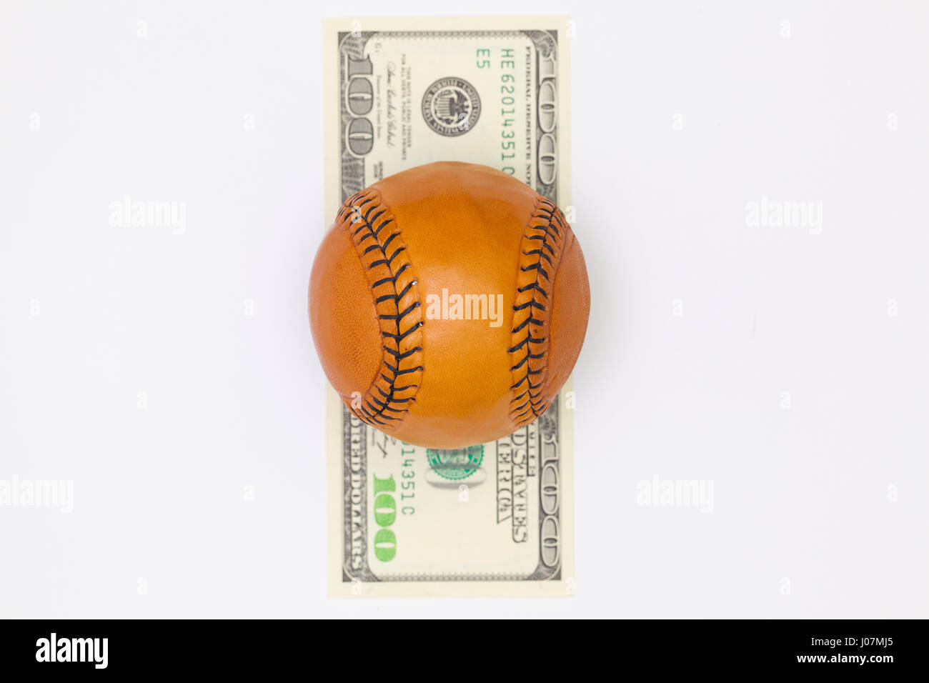 Balle de baseball en cuir et de billets en dollars US sur le tableau blanc. Photographie mise à plat Banque D'Images