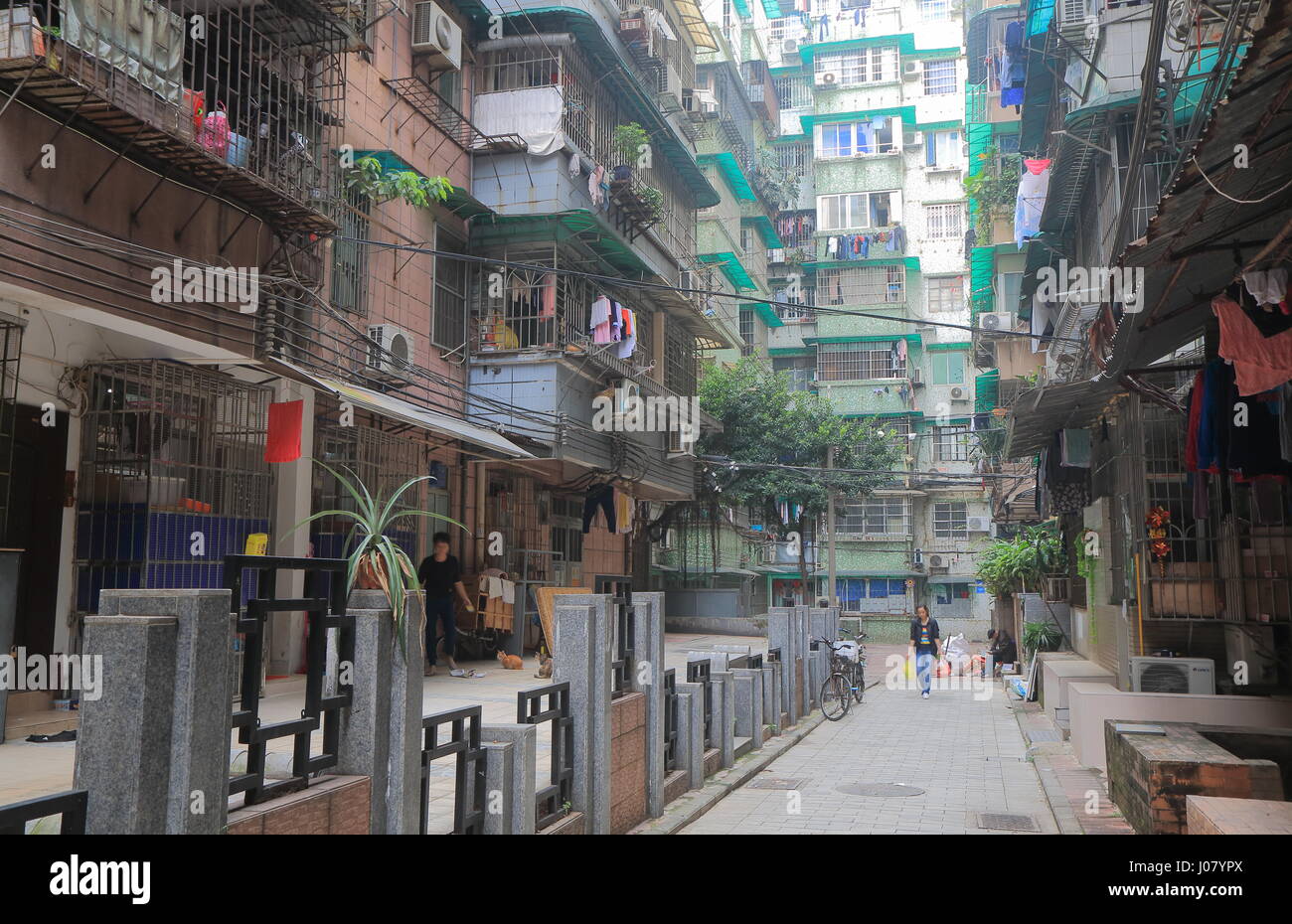 Les gens à pied sur une petite ruelle dans quartier résidentiel de Guangzhou en Chine. Banque D'Images
