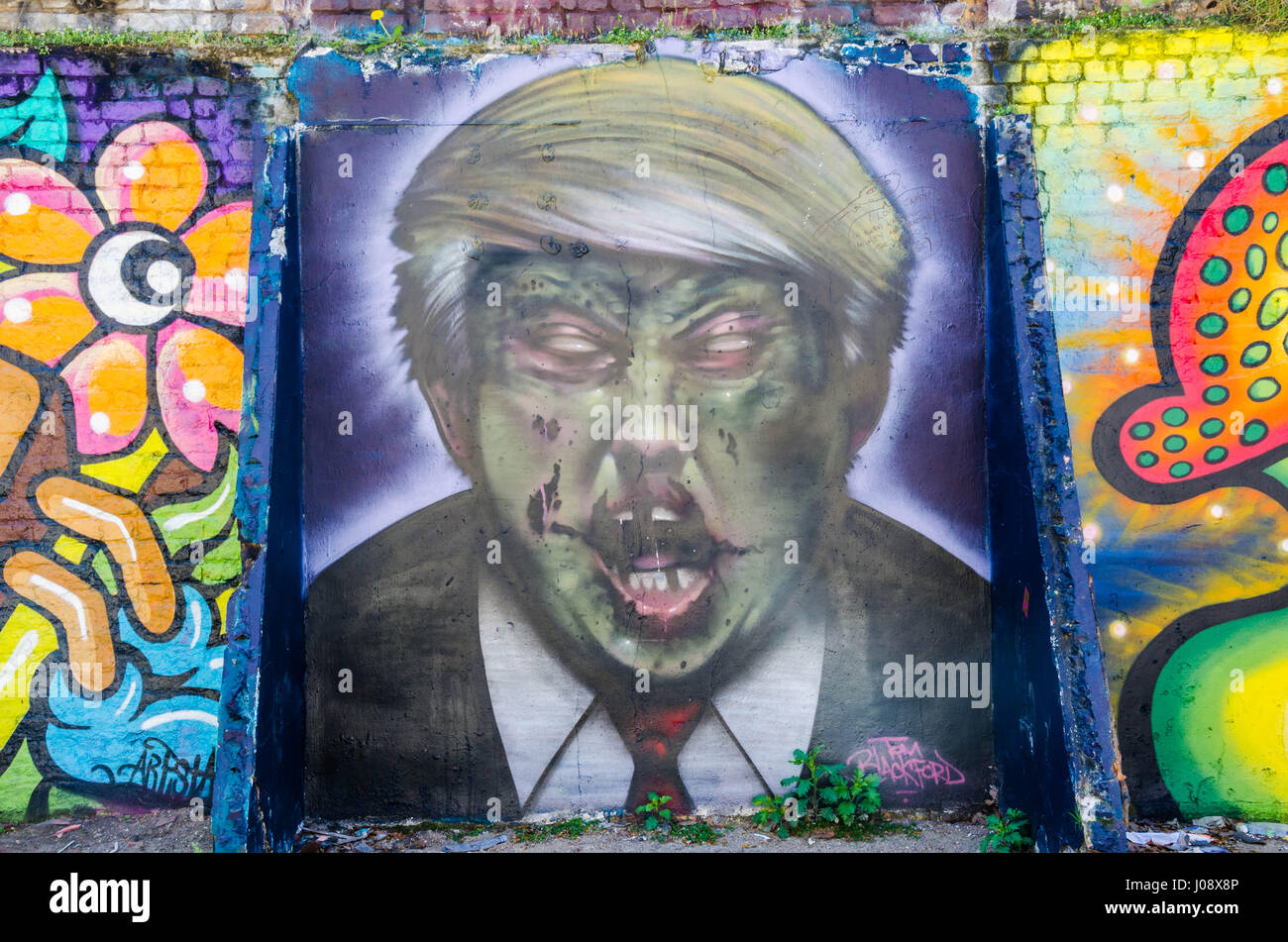 Un artiste de rue a fait une déclaration politique à l'Est de Londres en peignant un portrait à la démoniaque de Donald Trump sur un mur près de Brick Lane. Banque D'Images