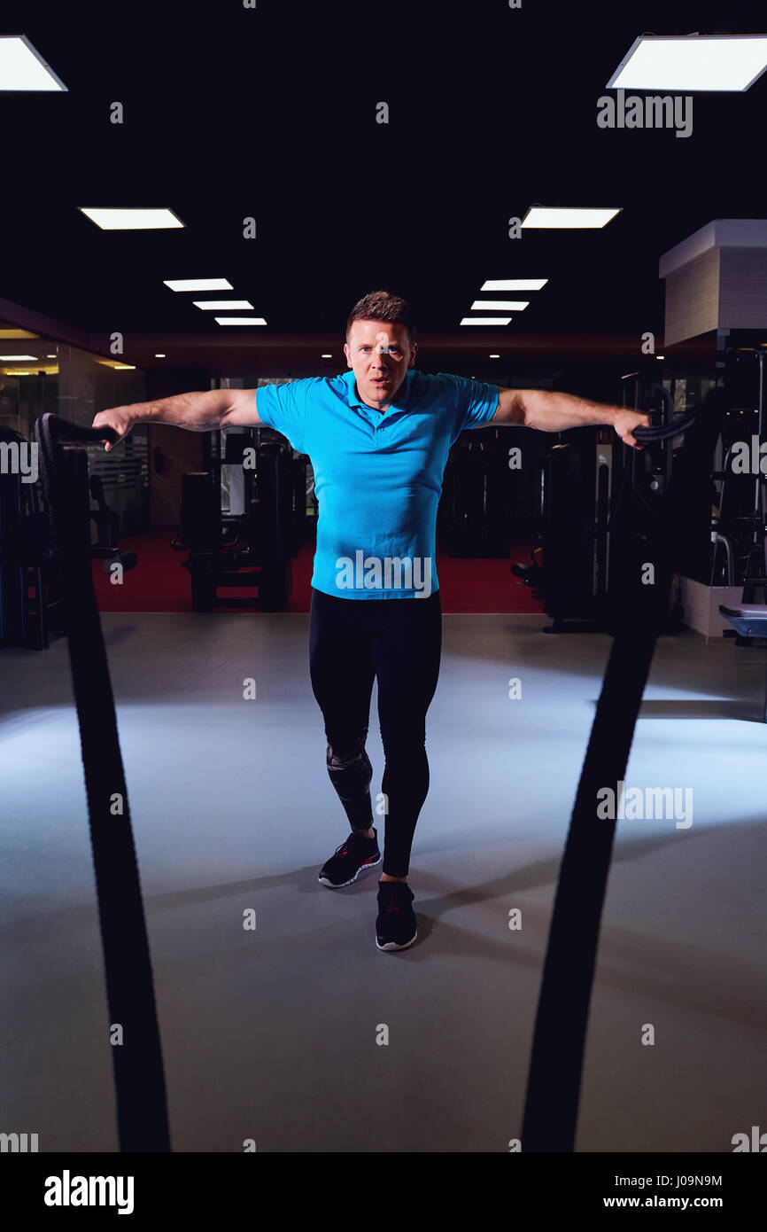 L'homme est de faire les exercices l'élaboration avec une corde dans la salle de sport Banque D'Images