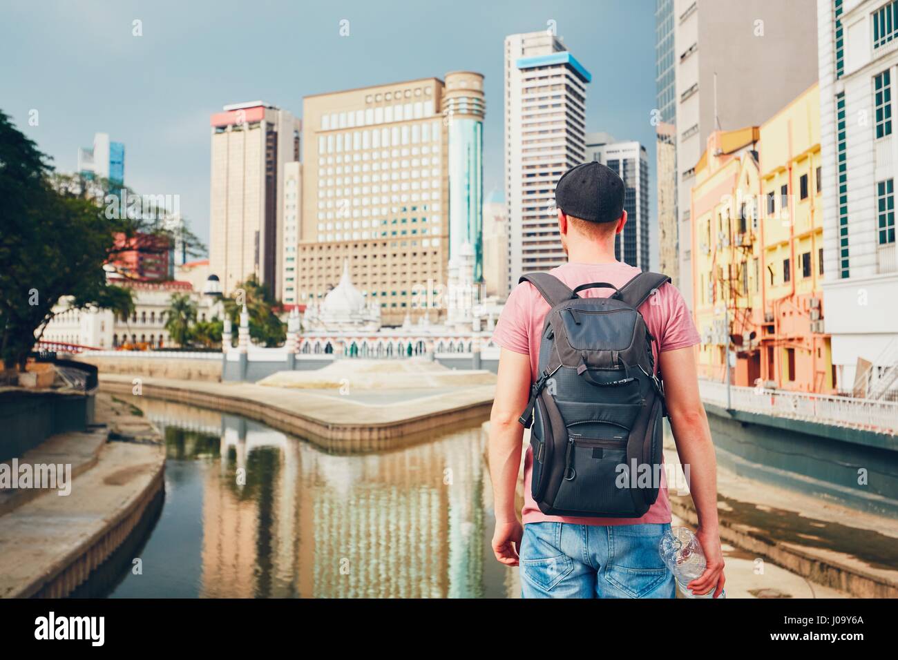 Les jeunes sur l'observation touristique ville moderne avec des gratte-ciel et de vieux bâtiments traditionnels et Mosquée Jamek Masjid à Kuala Lumpur Banque D'Images