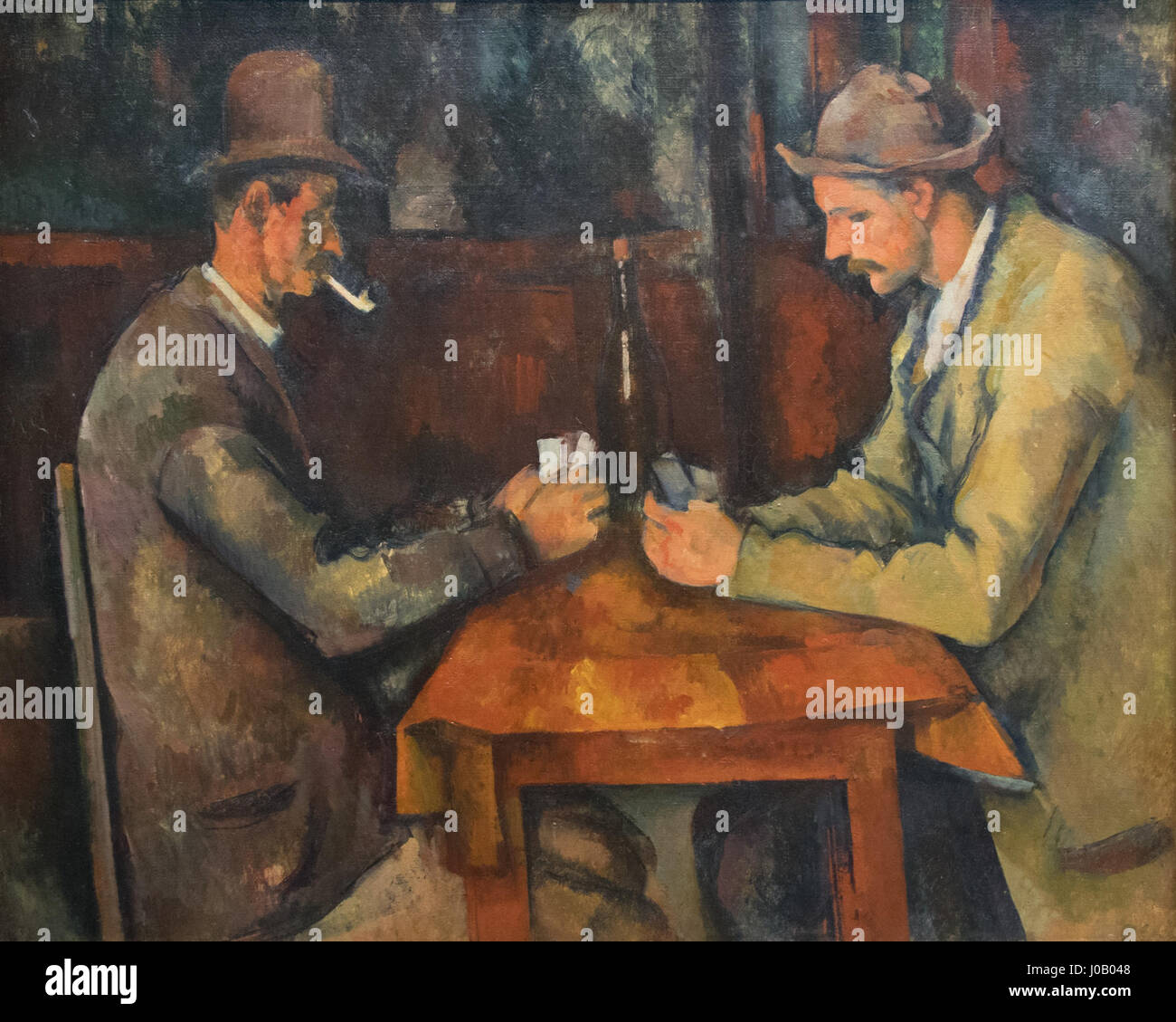 Les joueurs de cartes de Paul Cézanne est une série de peintures à l'huile du début des années 1890 représentant des paysans provençaux engagés dans des jeux de cartes, mettant en valeur son exploration de la forme et de la couleur. Banque D'Images