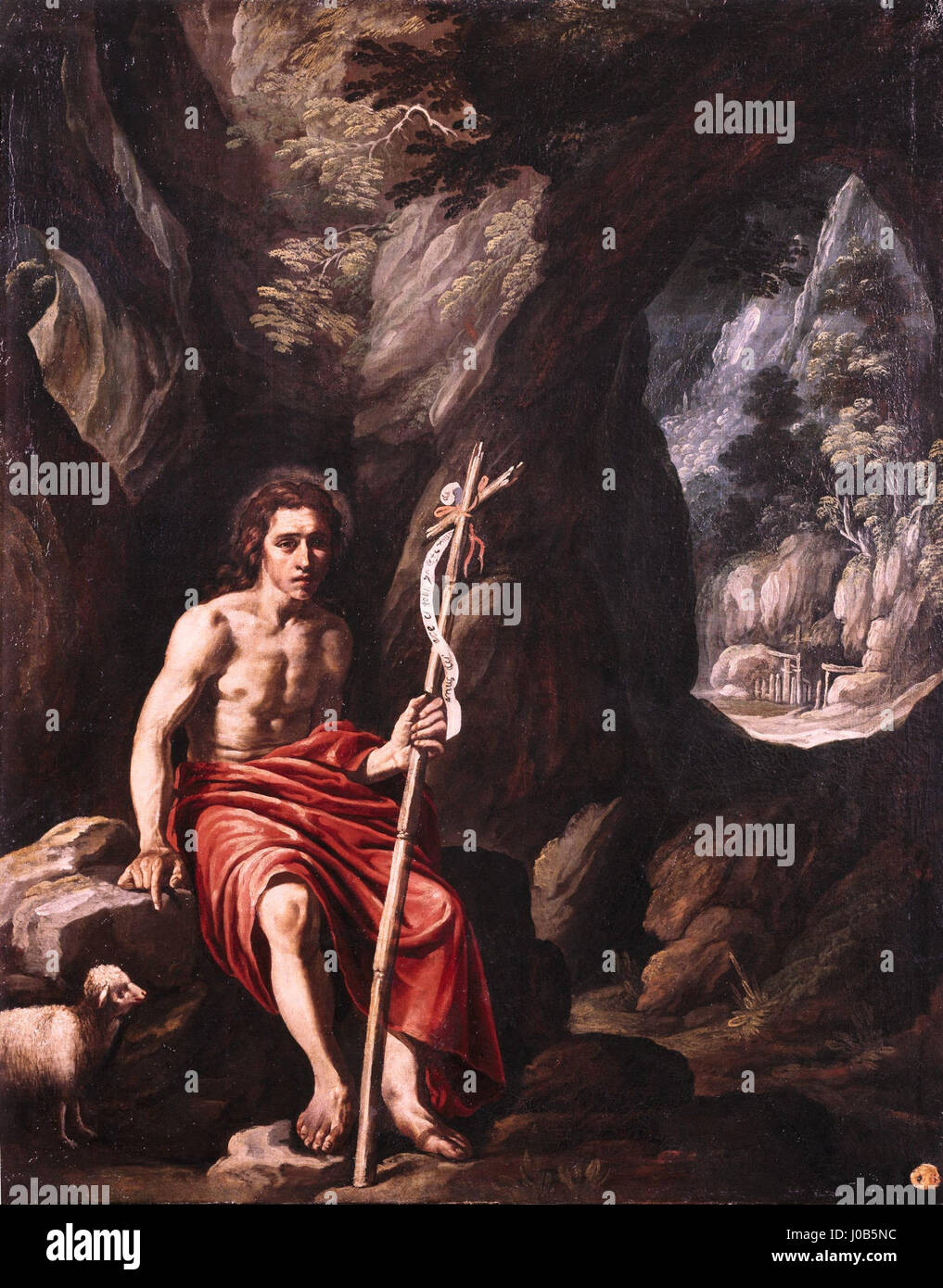 'San Juan Bautista en el desierto' de Luis Tristán, logé dans le Museo del Prado, représente Jean-Baptiste dans le désert, mettant en valeur le style baroque espagnol avec ses couleurs vives et ses contrastes spectaculaires. Banque D'Images