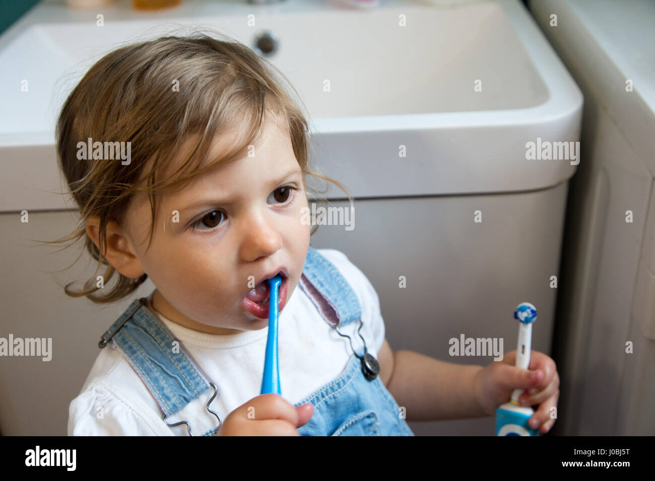 Tout Petit Fille Se Brosser Les Dents A L Aide D Une Brosse A Dents Pour Enfants Adultes Et De Tenir Une Brosse A Dents Electrique Dans Son Autre Main Elle Est De 16 Mois Tout Petit Fille Se Brosser Les Dents A L Aide D Une Brosse A Dents Pour Enfants Adultes Et De Tenir Une Brosse A Dents Electrique Dans Son Autre Main Elle Est De 16 Mois