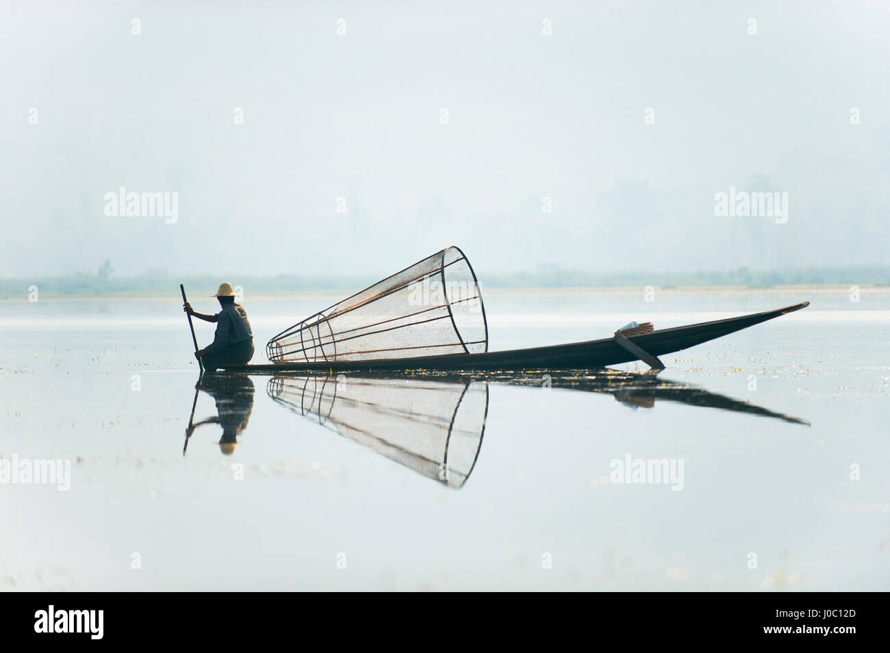 Un panier pêcheur sur le lac Inle analyse l'eau peu profonde et toujours des signes de la vie, le Myanmar (Birmanie), l'Asie Banque D'Images