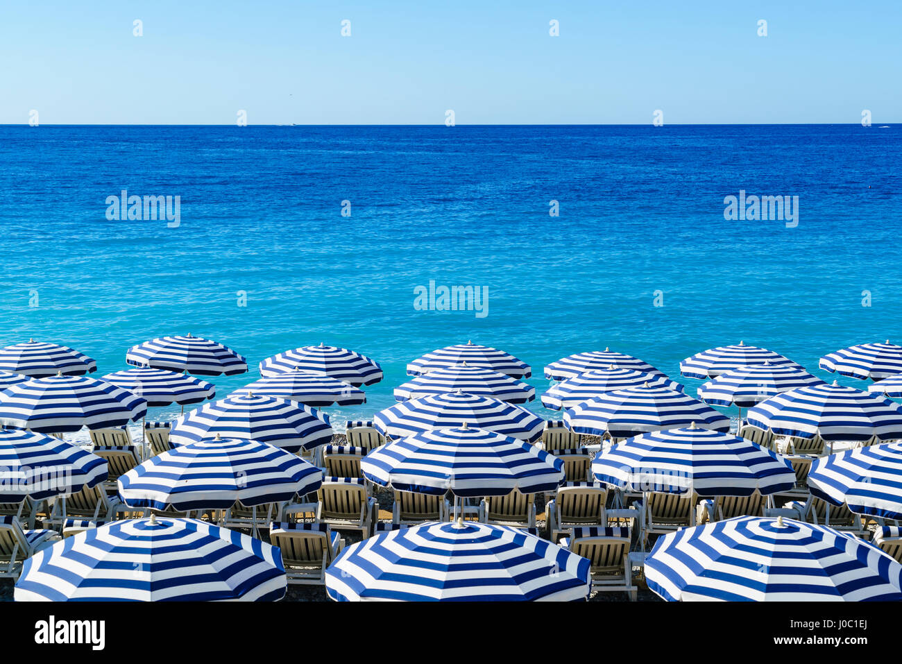 Des parasols de plage bleu et blanc, Nice, Alpes Maritimes, Côte d'Azur, Provence, France, Méditerranée Banque D'Images