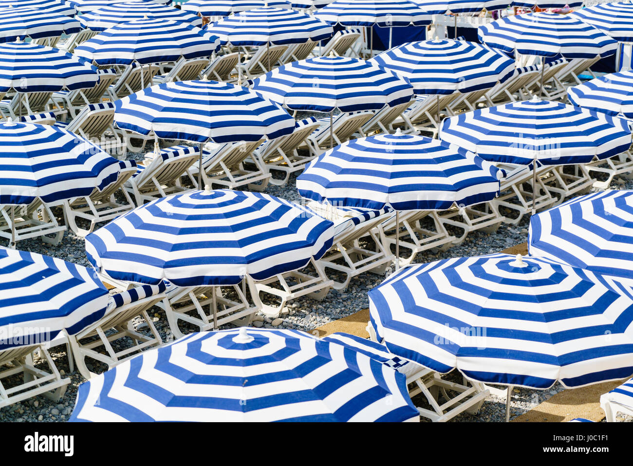 Des parasols de plage bleu et blanc, Nice, Alpes Maritimes, Côte d'Azur, Provence, France, Méditerranée Banque D'Images