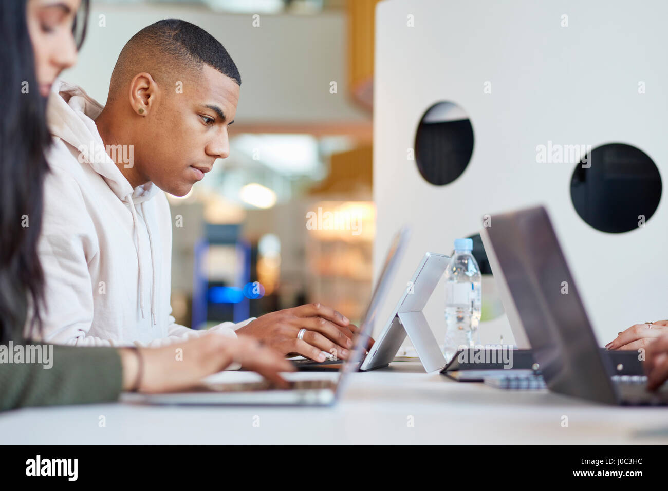 Les étudiants de l'université à l'aide d'ordinateurs portables et tablettes numériques, travailler ensemble Banque D'Images