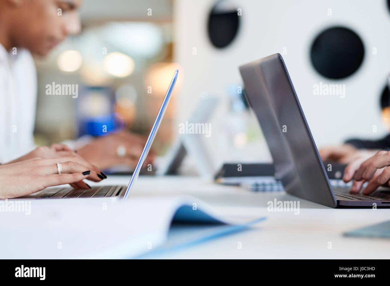 Les étudiants de l'université à l'aide d'ordinateurs portables et tablettes numériques, travailler ensemble Banque D'Images
