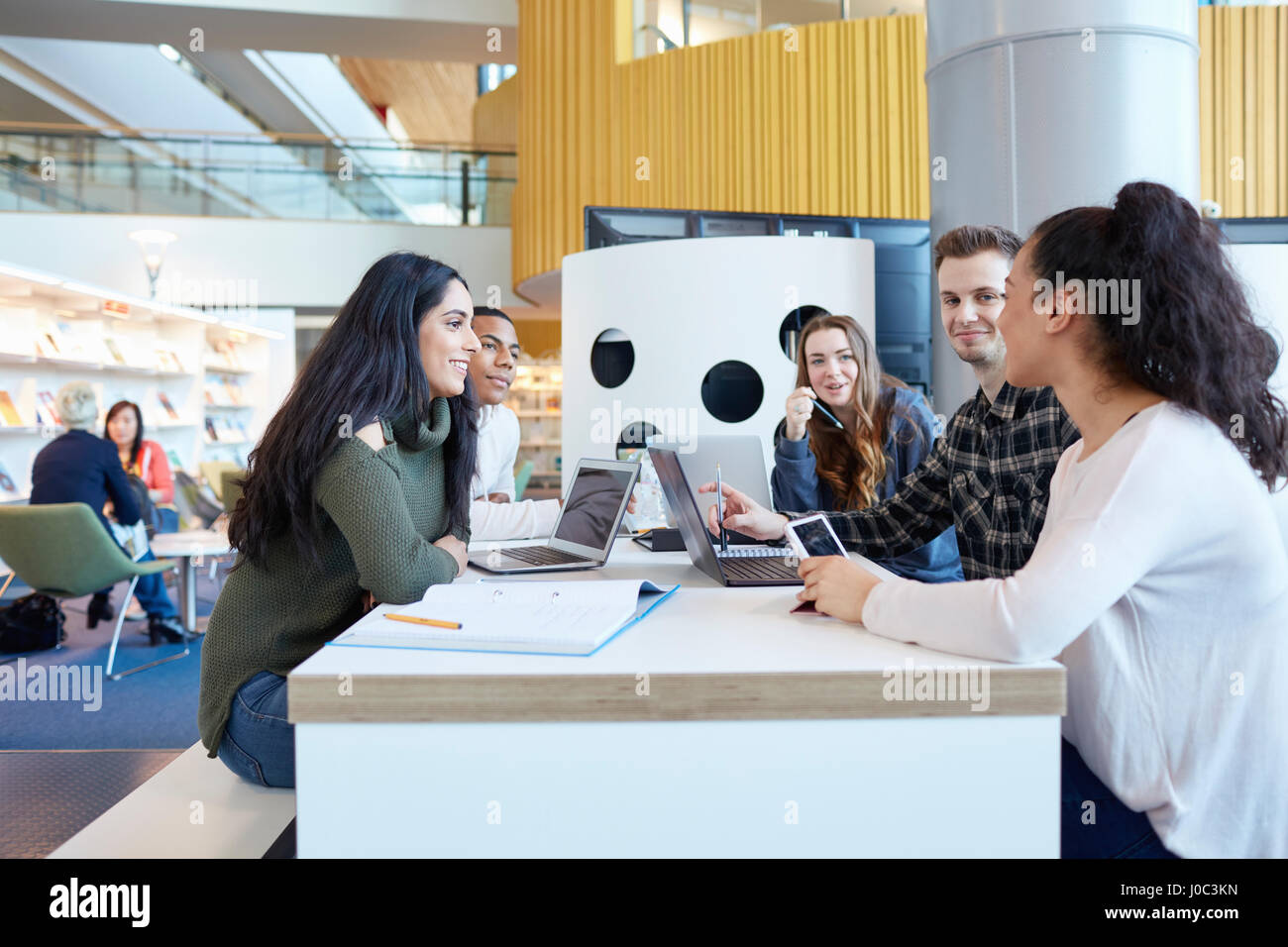 Les étudiants de l'université à l'aide d'ordinateurs portables et tablettes numériques, travailler ensemble Banque D'Images