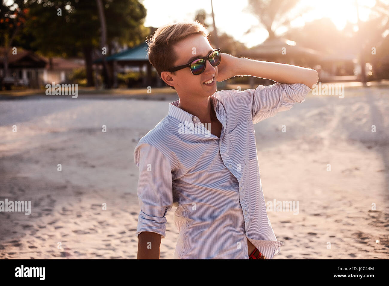 Jeune homme à la main sur l'oreille à beach, Koh Samui, Thaïlande Banque D'Images