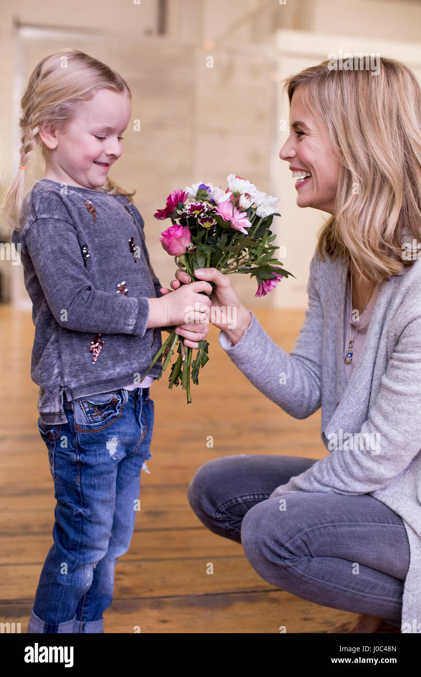 Jeune fille donnant mère bouquet de fleurs Banque D'Images