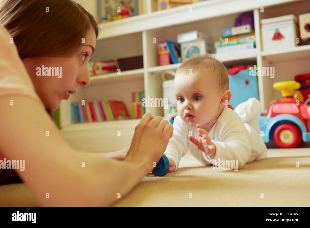 Mid adult woman and baby fille jouer sur jeux-de-chaussée Banque D'Images