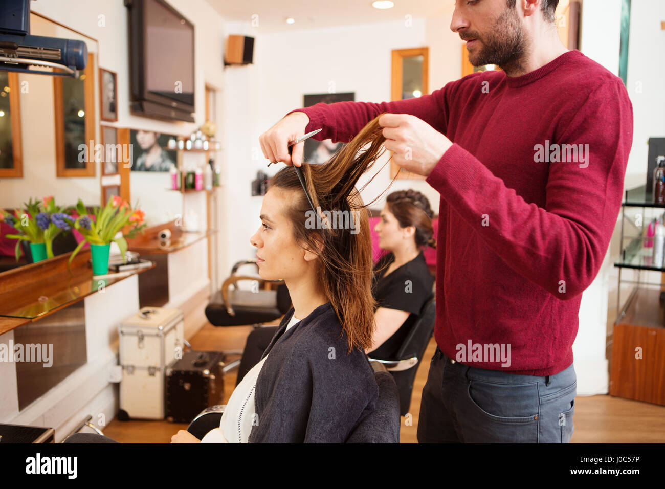 La clientèle féminine après avoir longtemps les cheveux bruns coupés dans un salon de coiffure Banque D'Images