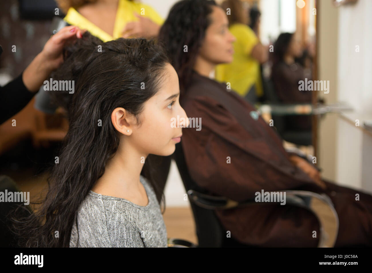 Mère et fille ayant leur style de cheveux dans un salon de coiffure Banque D'Images