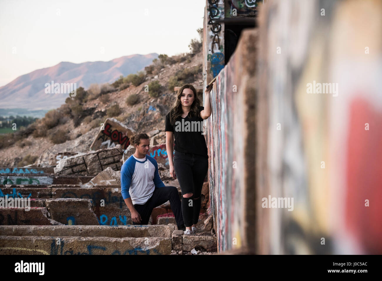 Jeune homme et femme à la découverte de l'écriture graffiti des murs à ruiné la mienne Banque D'Images