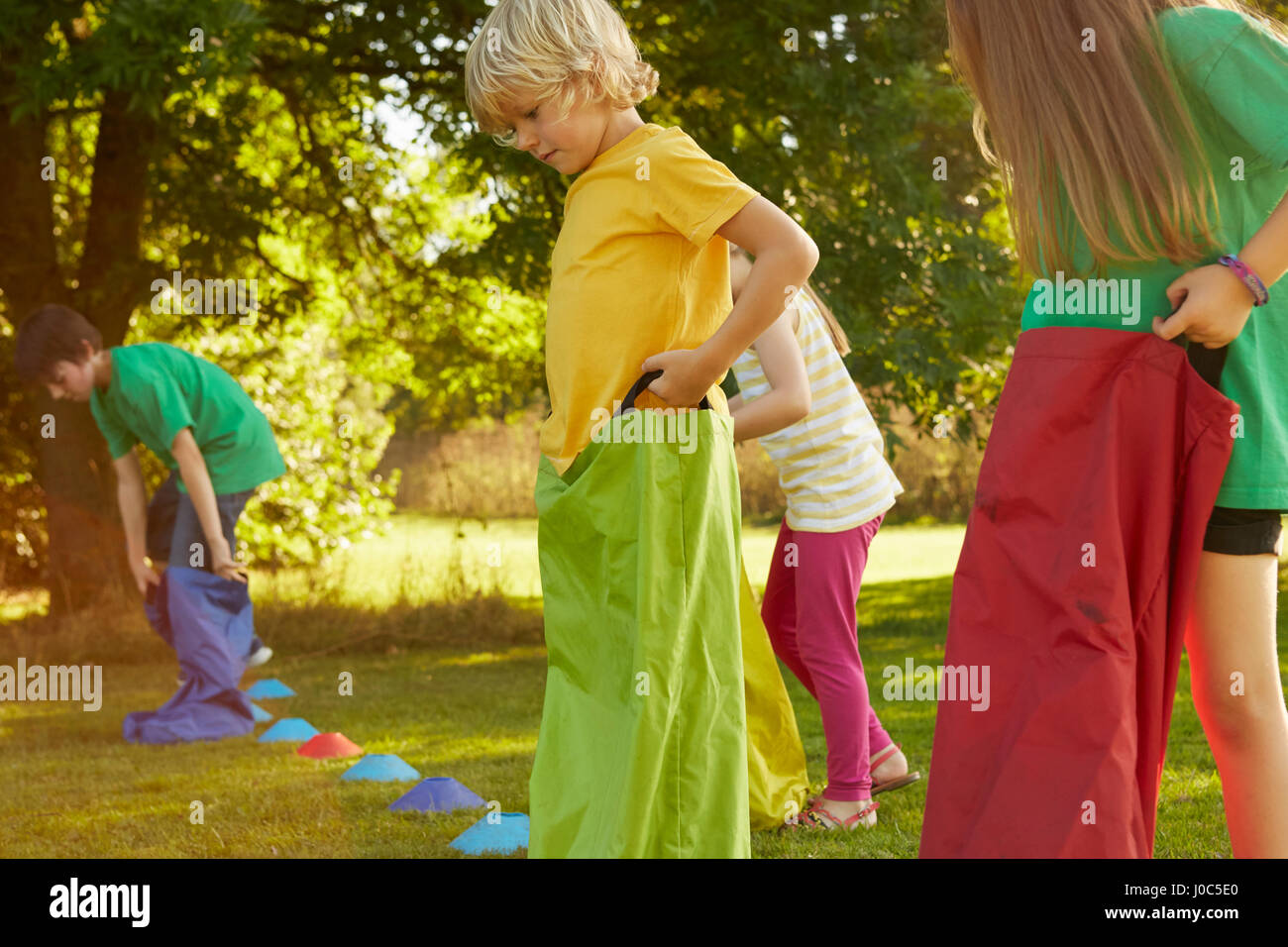 Les filles et les garçons la préparation de sac course sur la ligne de départ dans la région de park Banque D'Images