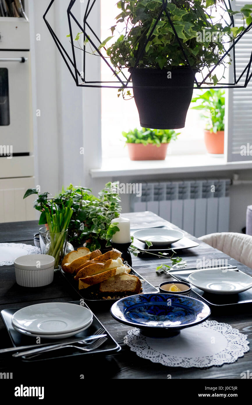 Ensemble table de cuisine avec des tranches de pain, de fines herbes et oignons de printemps Banque D'Images