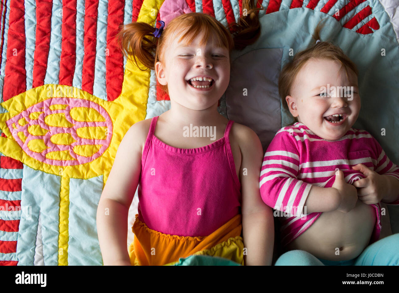 Portrait de deux jeunes sœurs lying on blanket, rire Banque D'Images