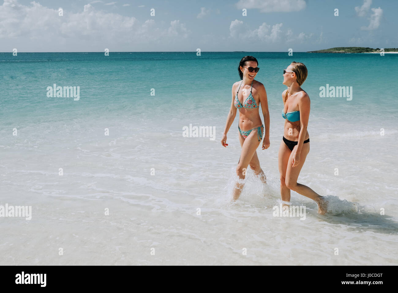 Deux sœurs adultes promenade dans la mer bleue, Anguilla, Saint Martin, Caraïbes Banque D'Images