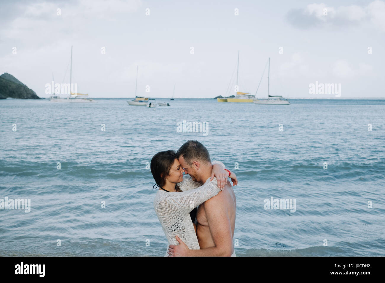Couple standing par mer, s'étreindre, face à face, Saint Martin, Caraïbes Banque D'Images