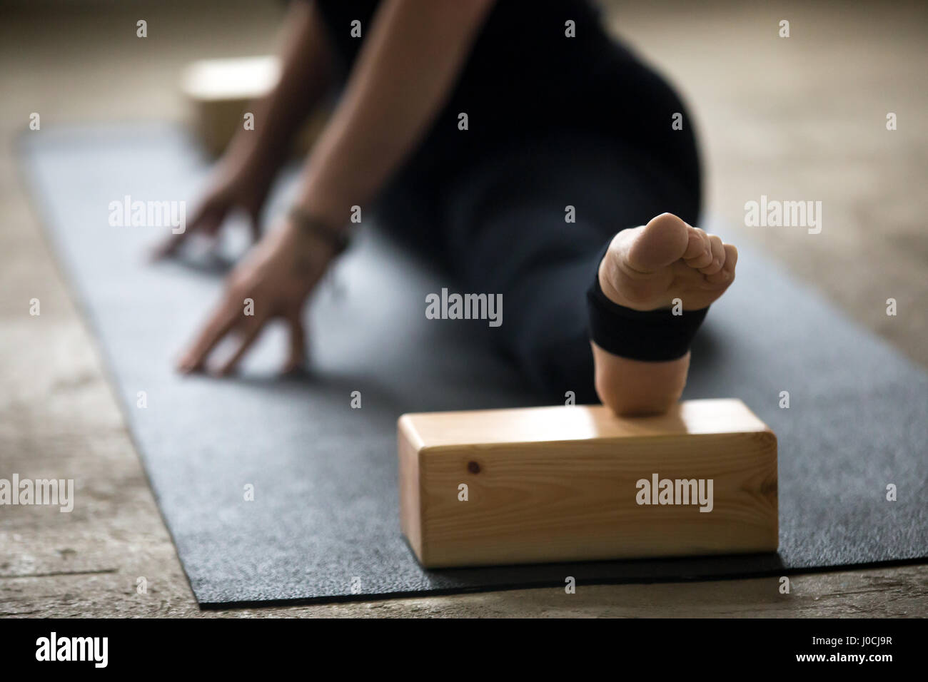 Close up of woman doing splits avec bloc pour étirer profonde Banque D'Images