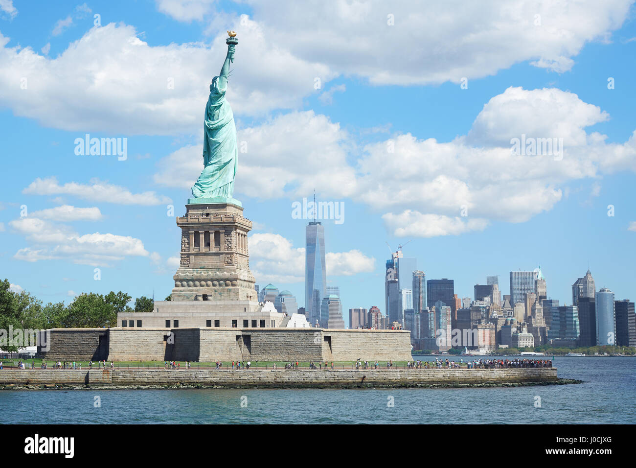 Statue de la liberté et de l'île de New York en une journée ensoleillée, ciel bleu et nuages blancs Banque D'Images