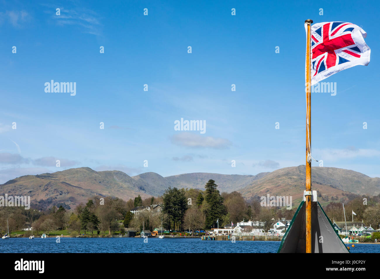 Le pilote de l'Union Jack (drapeau avec bordure blanche autour), volant sur un bateau voyageant sur le lac Windermere dans le Lake District, UK. Banque D'Images