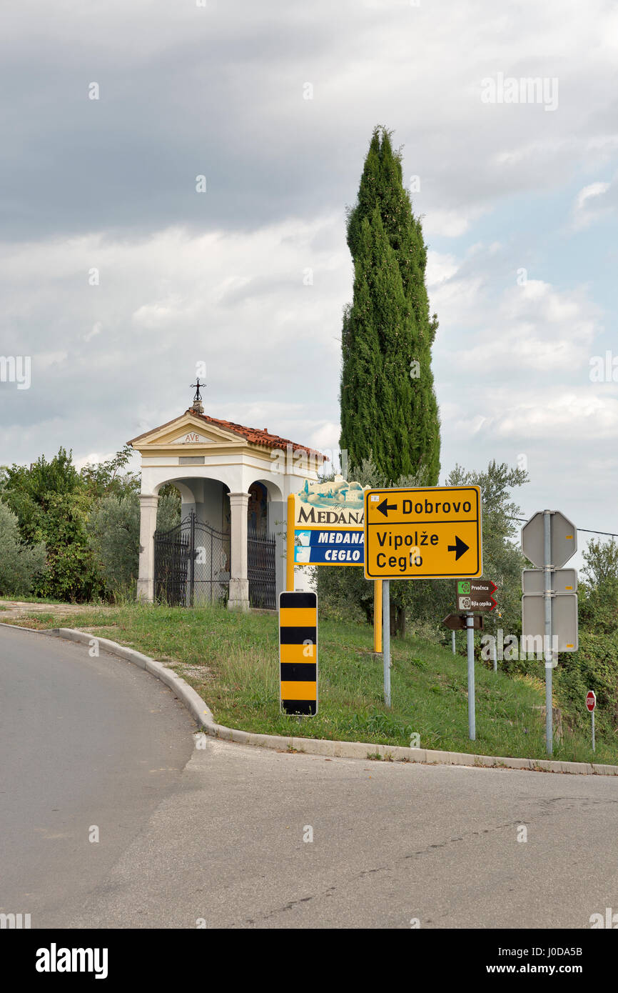 La Slovénie, MEDANA - Septembre 27, 2016 : la signalisation routière et petit oratoire à l'entrée du village. Le Medana est situé dans les collines de Gorizia, un pro du vin Banque D'Images