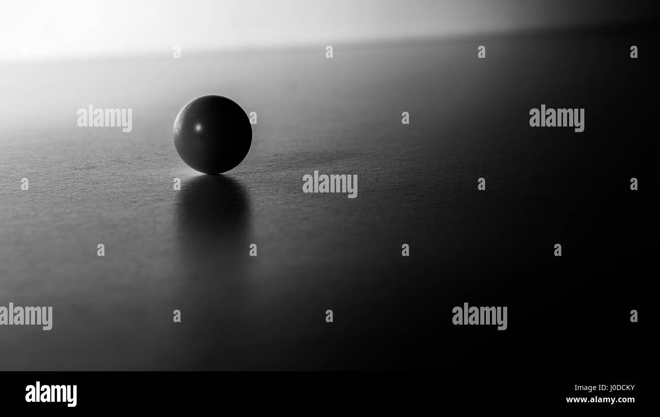 Le minimalisme dark ball sur un bureau blanc en noir et blanc Banque D'Images