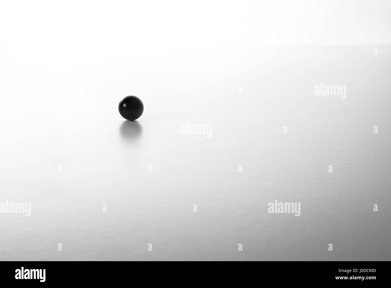 Ballon noir minimaliste sur un tableau blanc en noir et blanc Banque D'Images