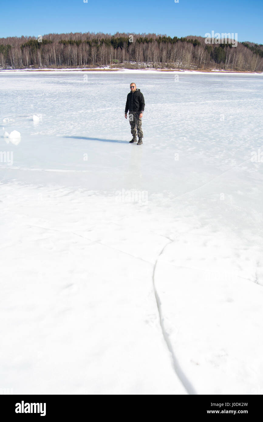 L'homme se dresse sur la surface du lac gelé Banque D'Images